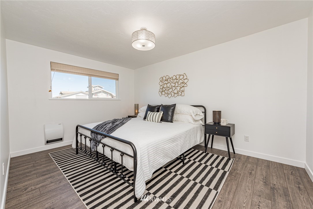 271 3 Crabs Road Sequim, WA 98382 - Photo 36 of 40 a bedroom with a bed and wooden floor