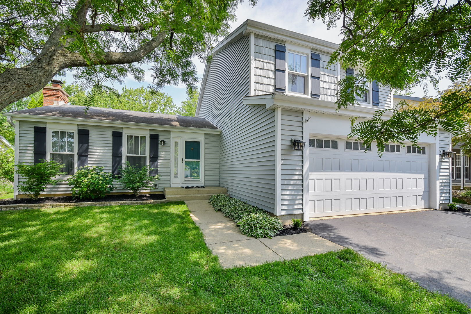 a front view of a house with a garden and yard