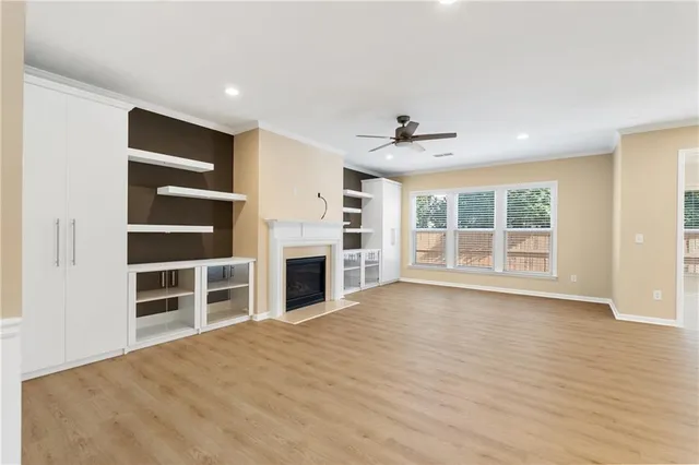 a view of an empty room with a kitchen and a window