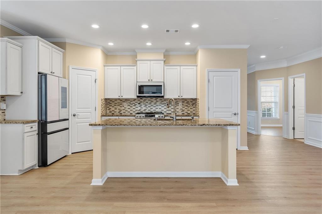 865 Great Glen Place Suwanee, GA 30024 - Photo 14 of 45 a kitchen with stainless steel appliances granite countertop a refrigerator and a stove top oven