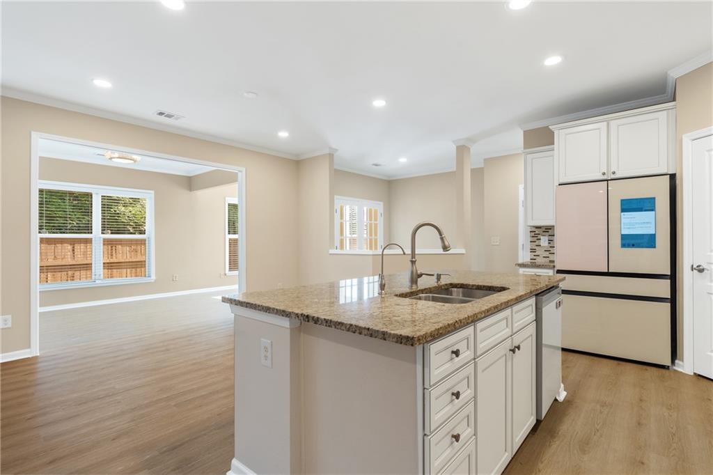 865 Great Glen Place Suwanee, GA 30024 - Photo 15 of 45 a kitchen with granite countertop a sink stove and refrigerator