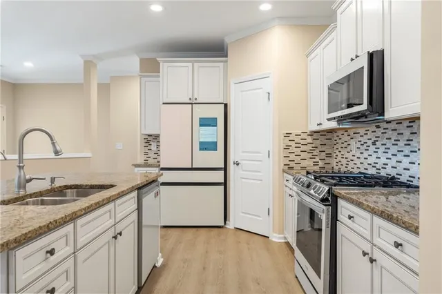a kitchen with stainless steel appliances granite countertop a sink stove and refrigerator