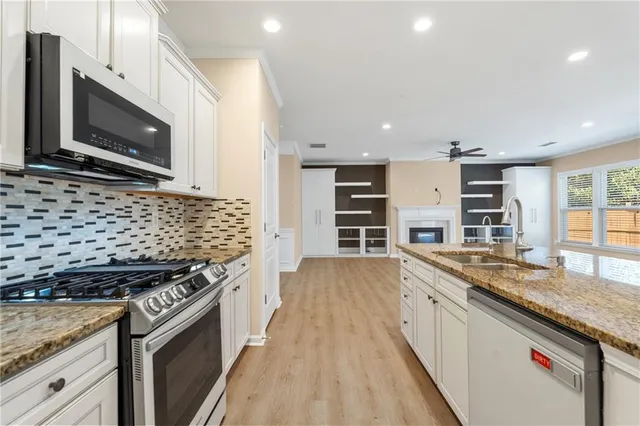a kitchen with stainless steel appliances granite countertop a stove and a microwave