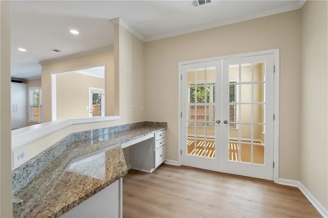 a view of an entryway with wooden floor and cabinet
