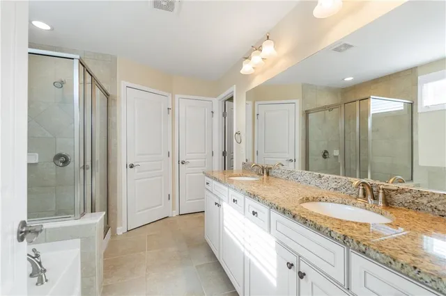 a bathroom with a granite countertop sink a mirror and shower