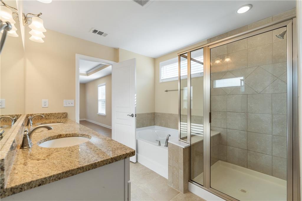865 Great Glen Place Suwanee, GA 30024 - Photo 37 of 45 a bathroom with a granite countertop sink a mirror and shower