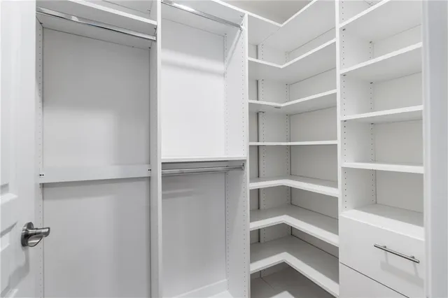 a view of walk in closet with empty racks