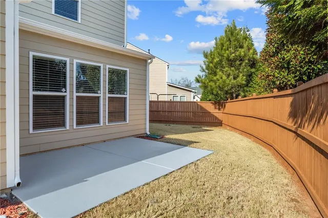 a view of backyard with barbeque and wooden fence