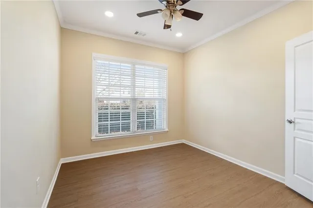 an empty room with a window and a fan