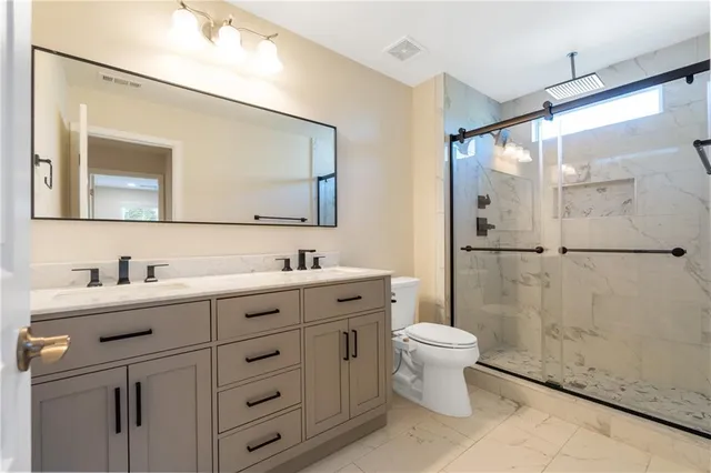 a bathroom with a toilet sink and mirror