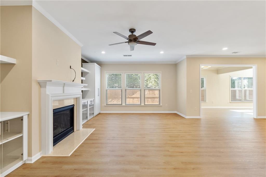 865 Great Glen Place Suwanee, GA 30024 - Photo 10 of 45 a view of a livingroom with a fireplace a chandelier and wooden floor