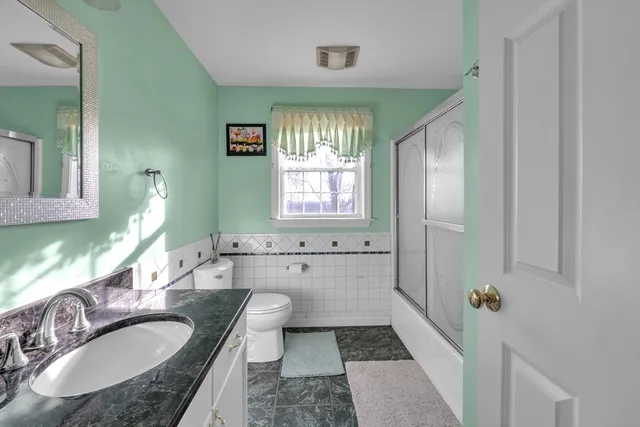 a bathroom with a granite countertop tub sink and mirror
