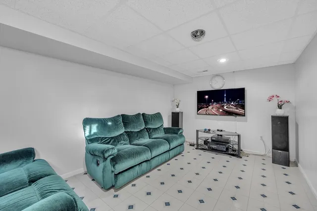 a living room with furniture a flat screen tv and kitchen view