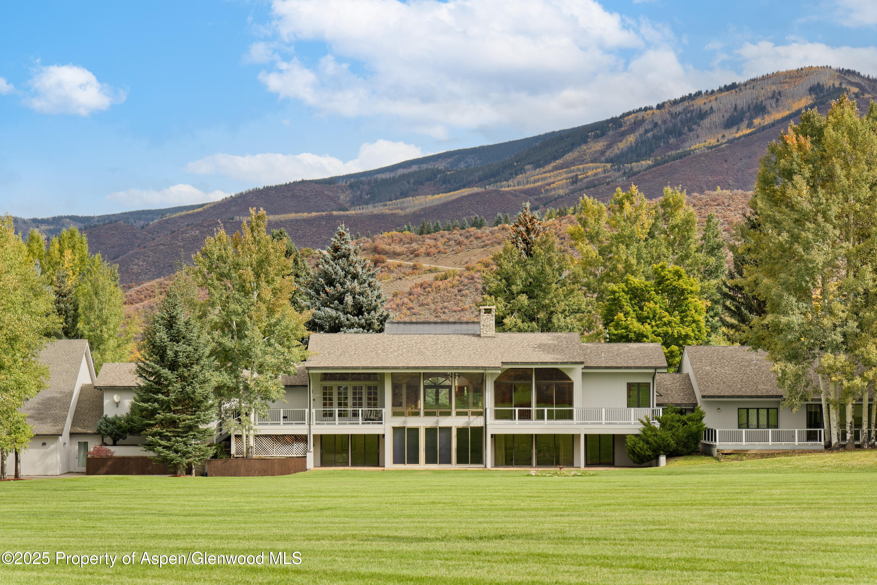 1650 McLain Flats Road Aspen, CO 81611 - Photo 15 of 72 a view of a white house with a big yard and large trees