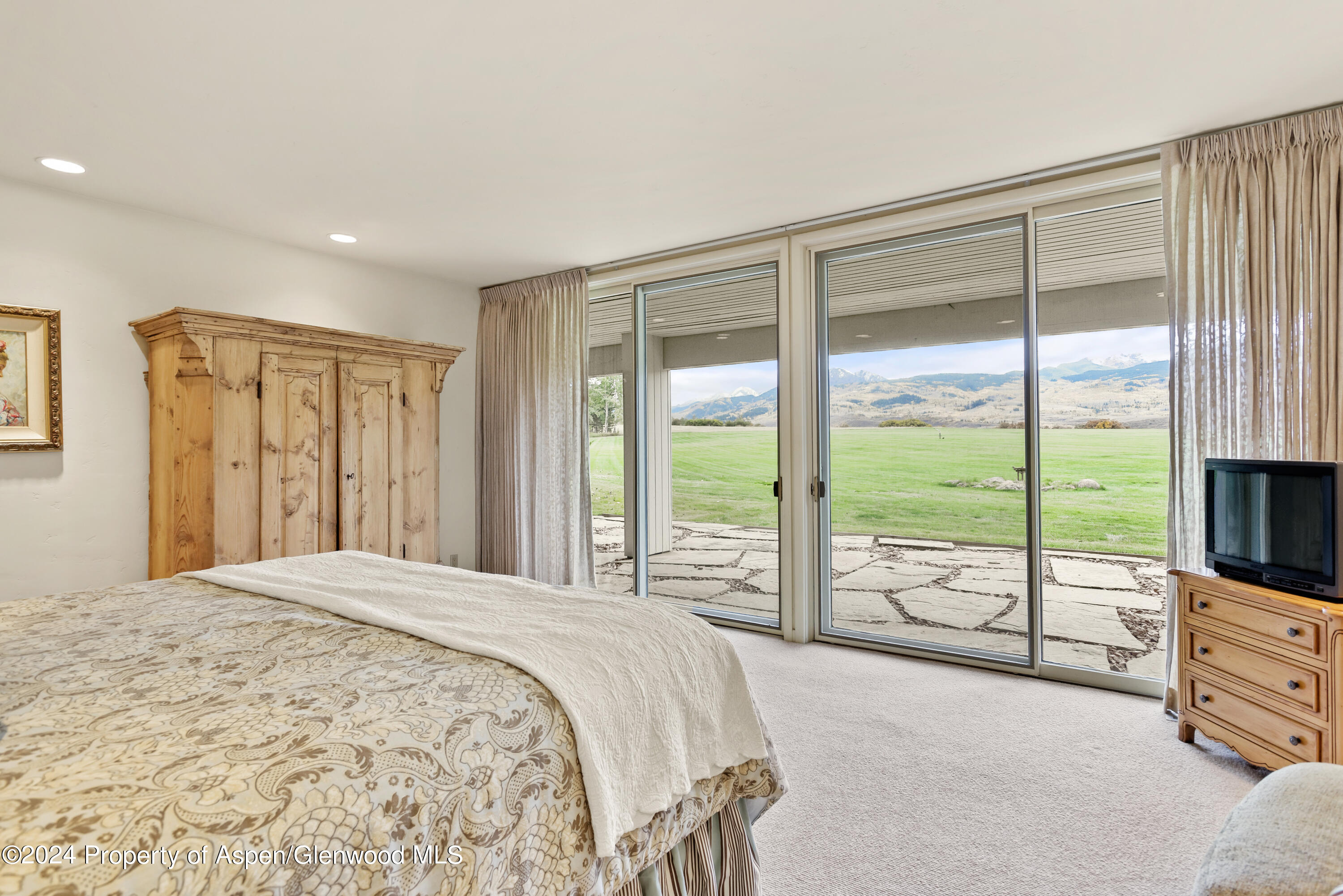 1650 McLain Flats Road Aspen, CO 81611 - Photo 39 of 72 a bedroom with a large bed and a flat tv screen