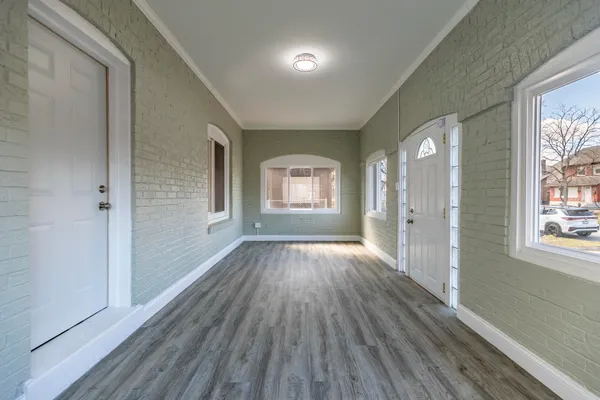 a view of a hallway with wooden floor and entryway