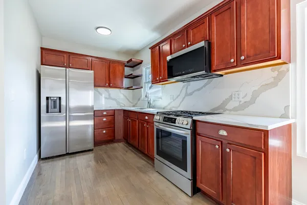 a kitchen with stainless steel appliances granite countertop a stove microwave and refrigerator
