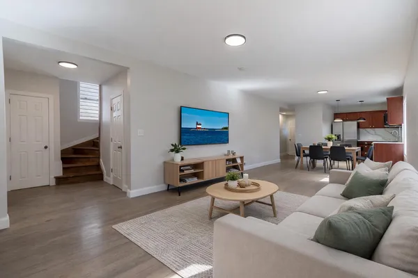 a living room with furniture and a view of kitchen