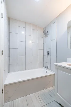 a bathroom with a bathtub shower sink vanity and toilet