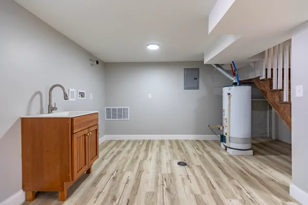 a view of an empty room with wooden floor and stairs