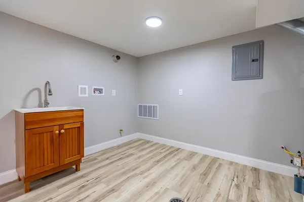 an empty room with wooden floor and entryway