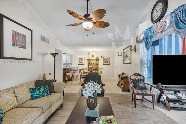 a living room with furniture chandelier and a flat screen tv