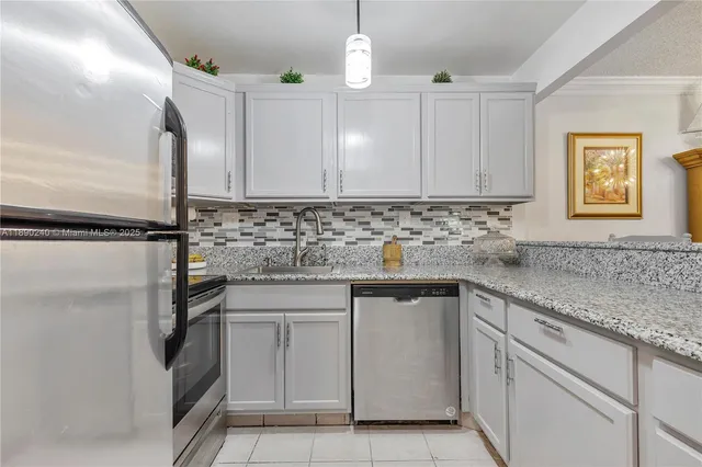 a kitchen with white cabinets and sink