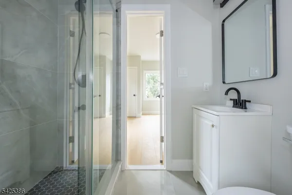 a bathroom with a sink and mirror with toilet