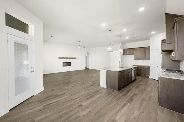 a large kitchen with stainless steel appliances kitchen island a large counter top and a wooden floors