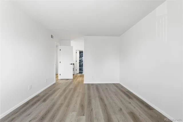 a view of an empty room with wooden floor