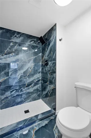 a bathroom with a toilet and a shower