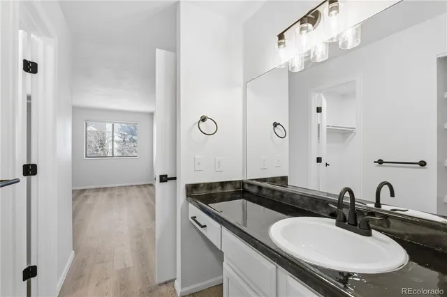 a bathroom with a granite countertop sink a mirror and a shower