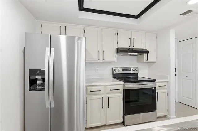 a kitchen with stainless steel appliances white cabinets and a stove