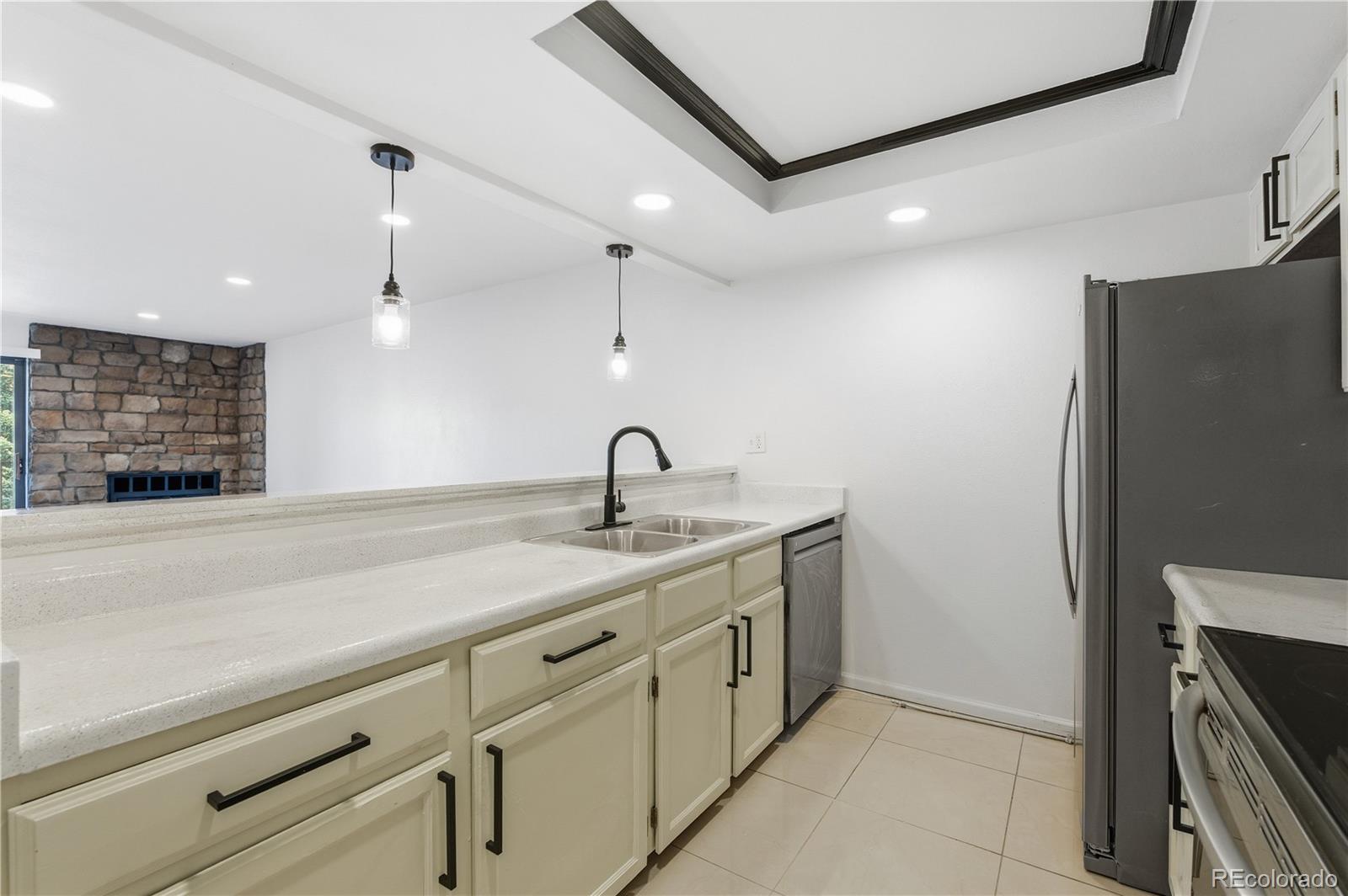 481 South Kalispell Way, Unit 306 Aurora, CO 80017 - Photo 9 of 43 a kitchen with a sink and a refrigerator