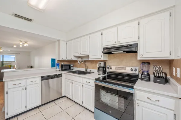 a kitchen with white cabinets and appliances