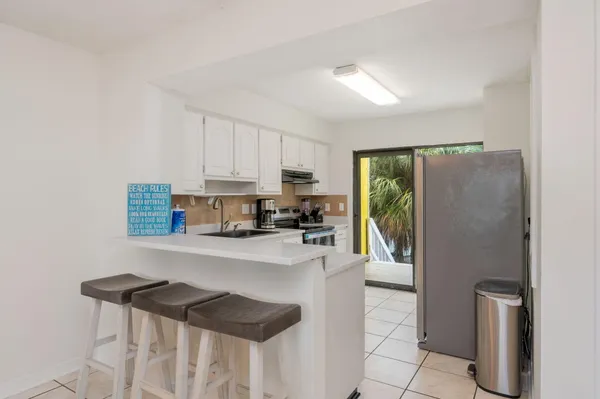 a kitchen with a refrigerator and a stove top oven
