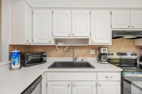 a kitchen with white cabinets and white appliances