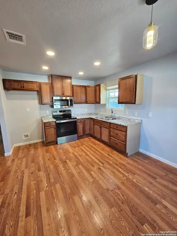 a large kitchen with stainless steel appliances granite countertop a stove and cabinets