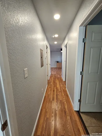 a view of a hallway with wooden floor