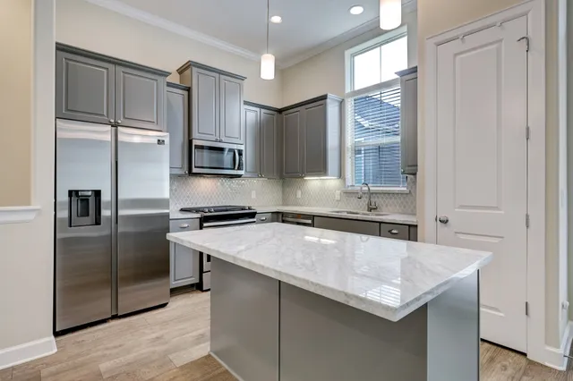 a kitchen with stainless steel appliances granite countertop a sink and a refrigerator