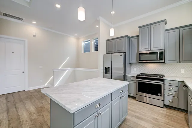 a kitchen with stainless steel appliances granite countertop a sink stove and refrigerator