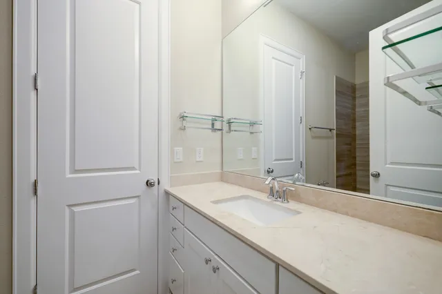 a bathroom with a granite countertop sink and a mirror