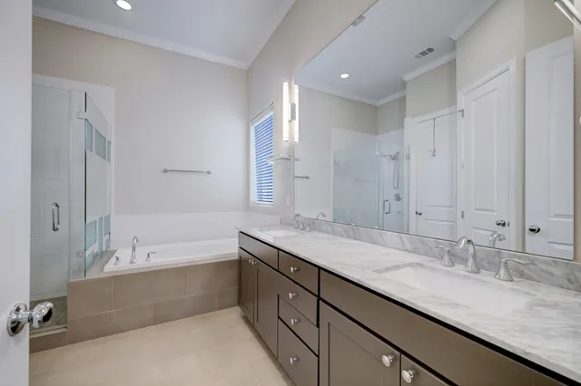 a bathroom with a granite countertop double vanity sink and mirror with bathtub