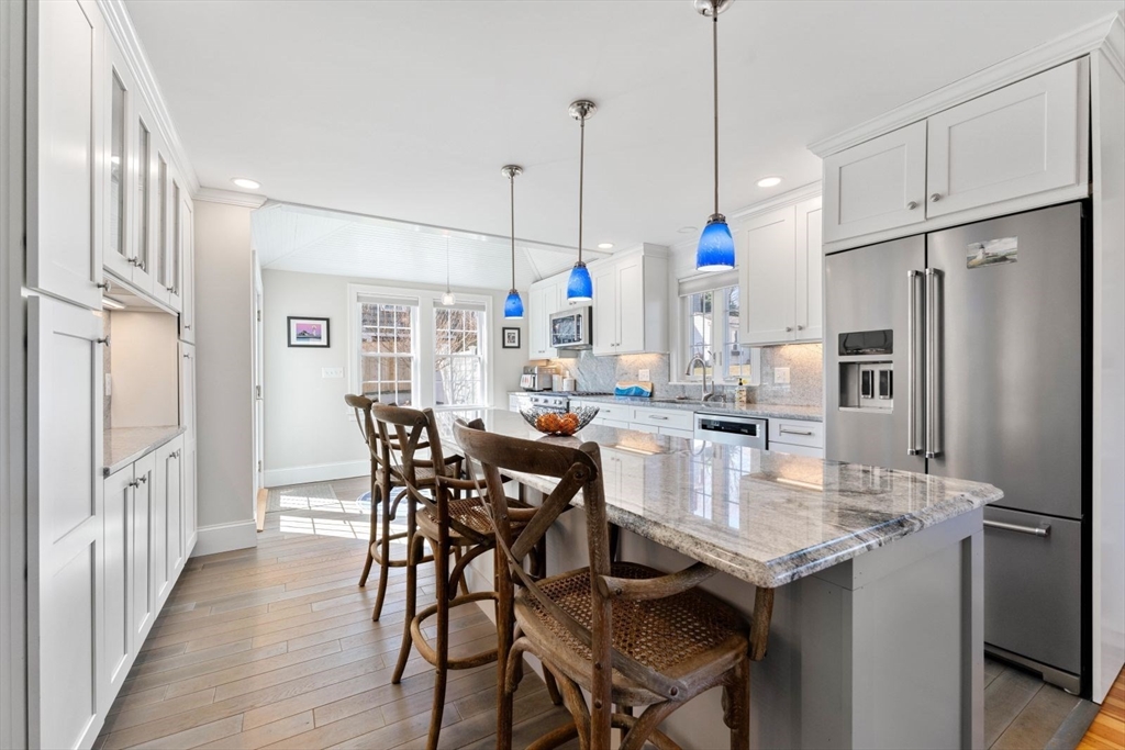 19 Damon Road Scituate, MA 02066 - Photo 7 of 33 a kitchen with stainless steel appliances granite countertop a dining table chairs refrigerator and microwave