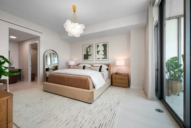 a spacious bedroom with a bed and a chandelier