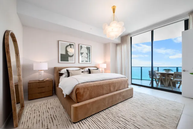 a bedroom with a large bed and a chandelier