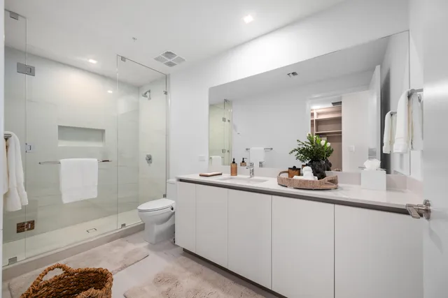 a bathroom with a sink a toilet and shower