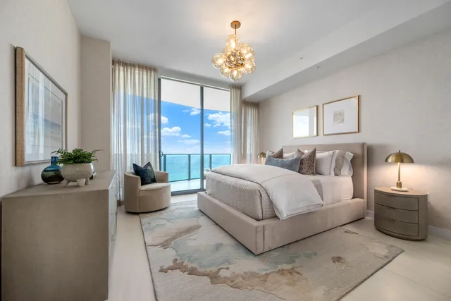 a spacious bedroom with a bed and a chandelier