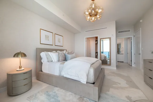 a spacious bedroom with a bed and a chandelier