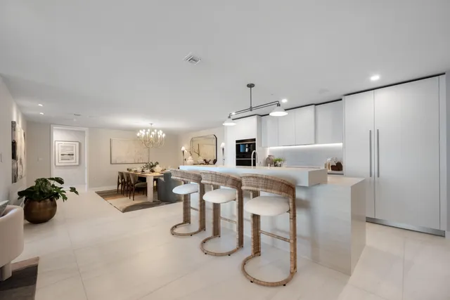 a kitchen with a sink a counter space and chairs